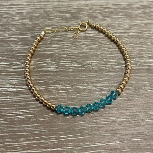 Gold beaded bracelet with teal gems